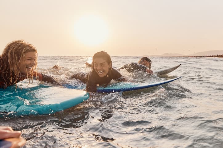 Estudiantes haciendo surf durante un viaje escolar